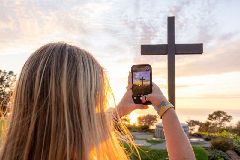 Girl takes photo of the PLNU cross on campus