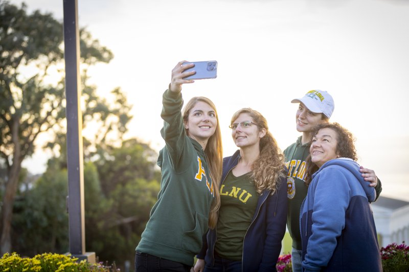 PLNU student taking selfie with her family in front of the Greek