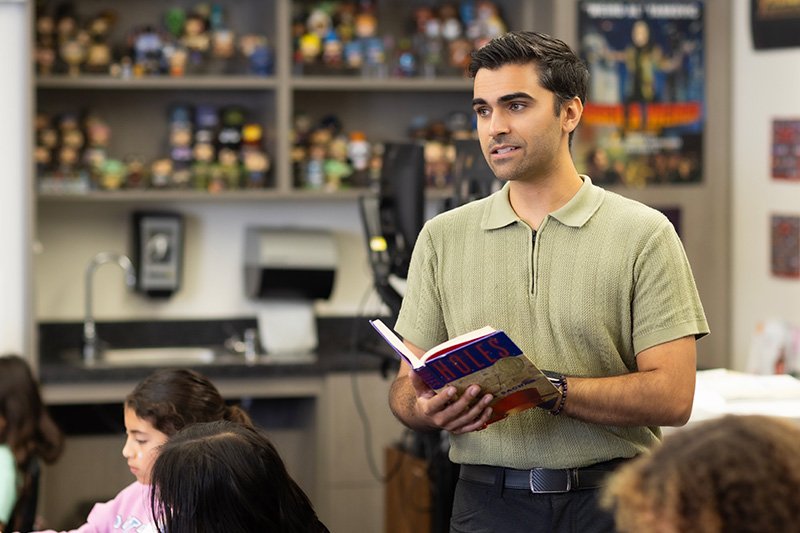 PLNU graduate student reads from book during class lecture.