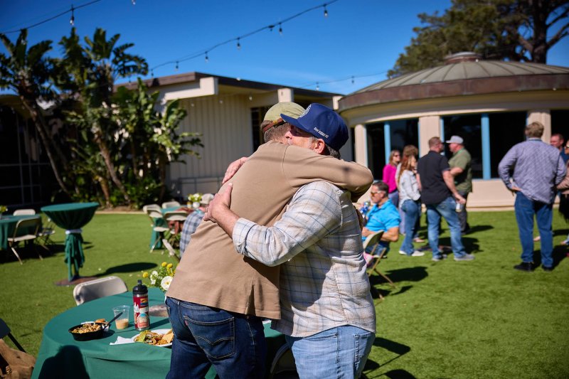 Two guest at PLNU's Welcome Week 2026 hug in an embrace in a socializing event.