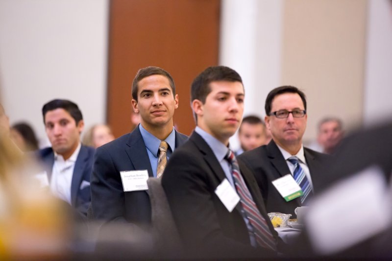 PLNU graduate students listen to a presentation at a networking event.