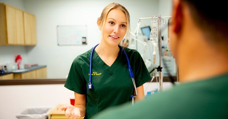 A PLNU nursing student explains a process to another nurse.
