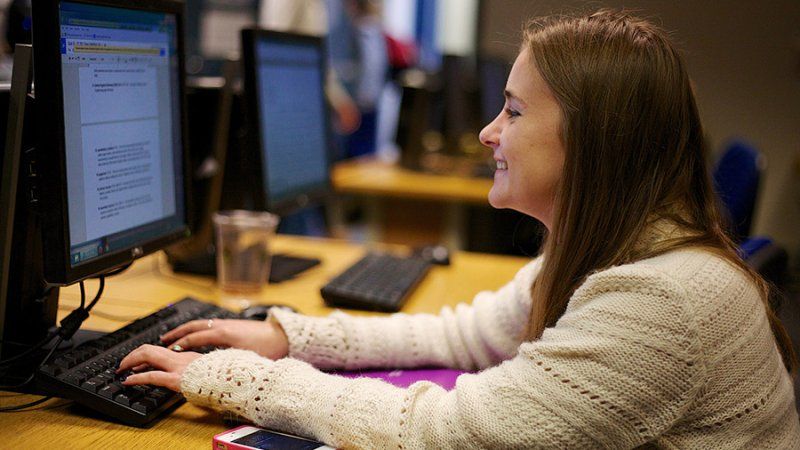 A female student works on a essay in the computer lab.