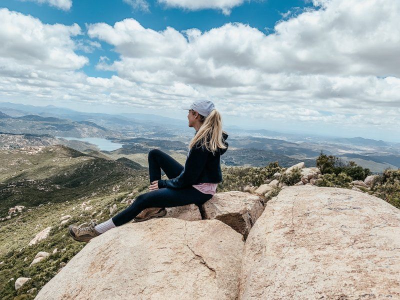 Female hiker sits on a rock at Iron Mountain in San Diego