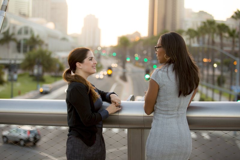 Two women in business attire talking