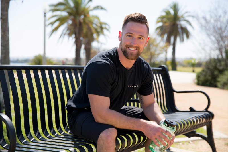 PLNU student sits on a bench after a morning run