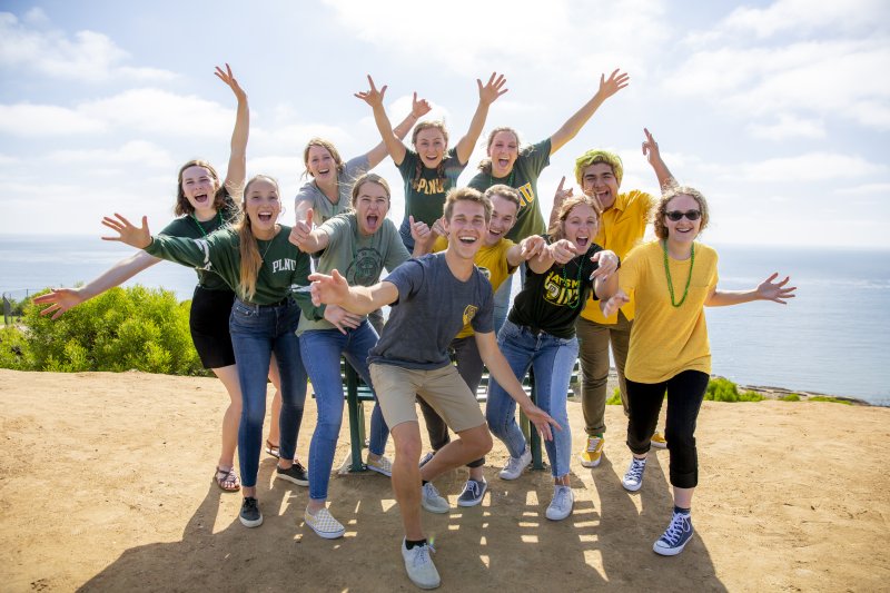 Group of PLNU students cheer and smile
