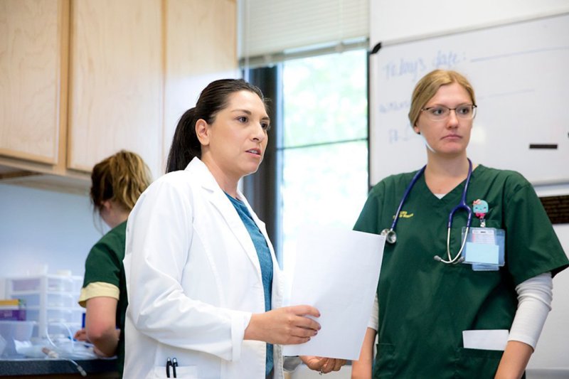 Many nurses are going back to earn their DNPs, pictured above is a nurse in scrubs and a DNP professional in their lab coat. 