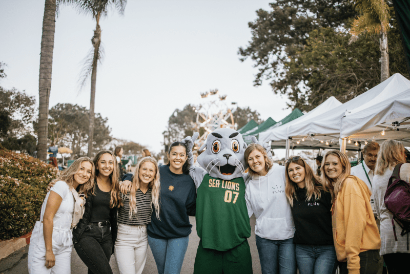 PLNU students posing with Splash the Sea Lion at the Homecoming Tailgate in 2019.