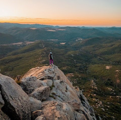 Hiker stands on the edge of Stonewall Peak in San Diego