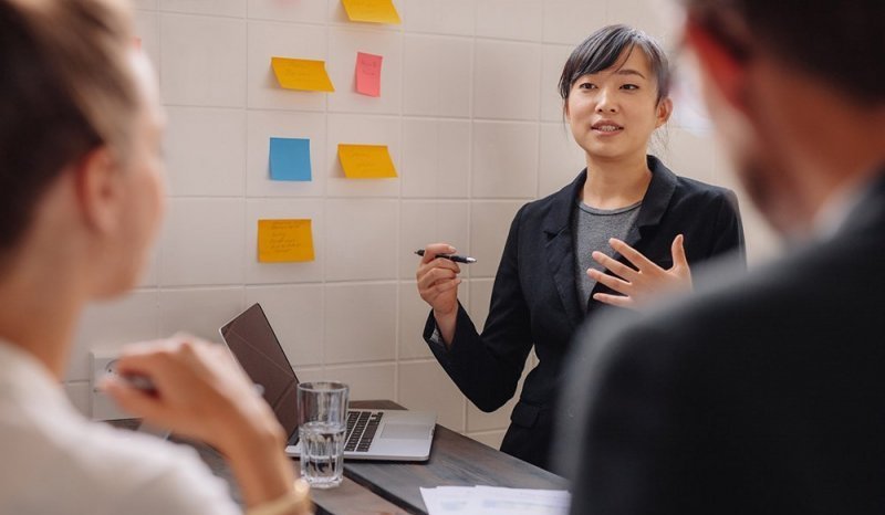 A woman gives a visual presentation to colleagues.