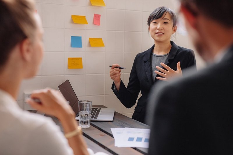 A woman gives a visual presentation to colleagues.