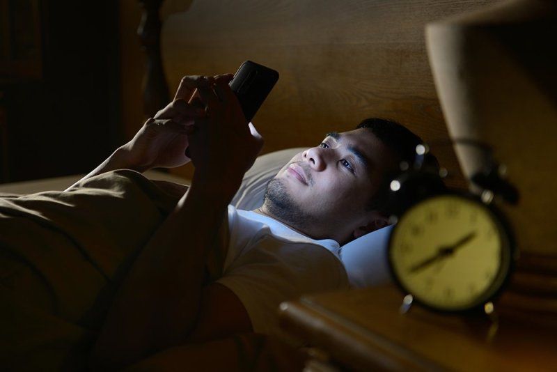Man on phone in bed 