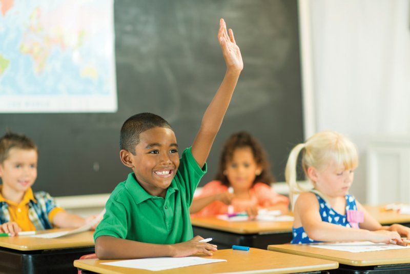 Boy raising his hand in classroom