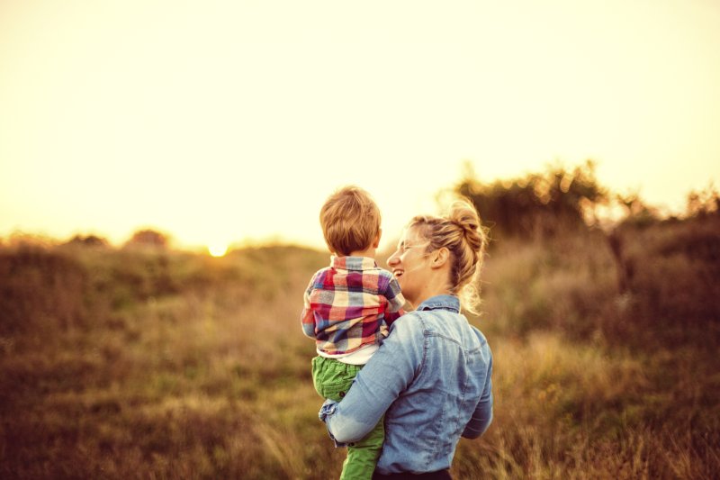 stock image of woman holding child in field