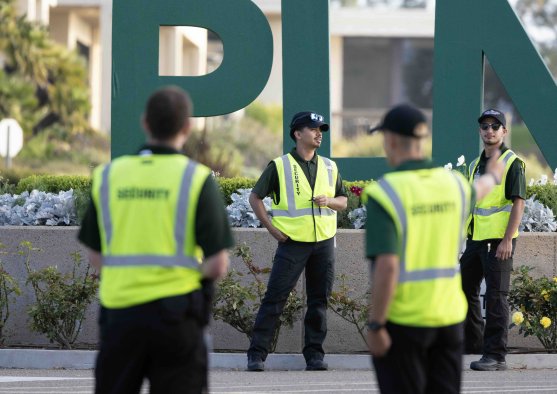 PLNU Public Safety officer assisting a driver at a campus entrance checkpoint.