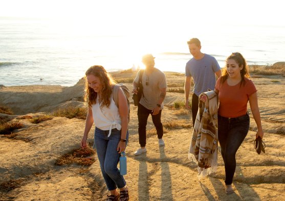 Undergraduate Students walking along cliffs during sunset
