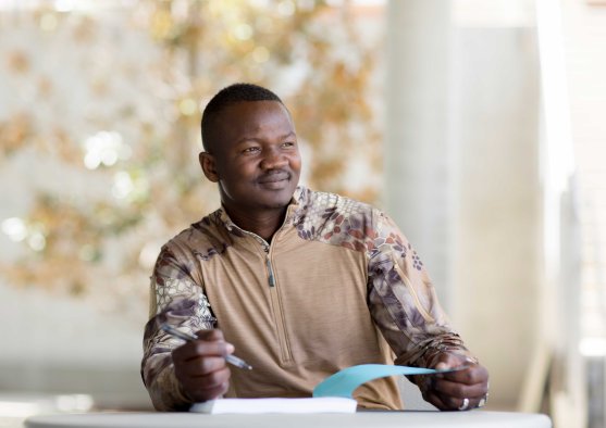 Man works on homework outside.