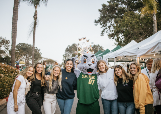 PLNU students posing with Splash the Sea Lion at the Homecoming Tailgate in 2019.