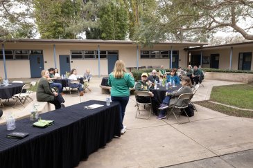 Group has a meal outside the courtyard of Evans Hall