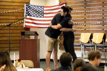 Military veterans hug at the Warrior Breakfast.