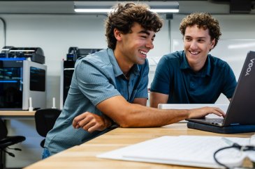 PLNU engineering students work together on a computer project in a lab equipped with 3D printers.
