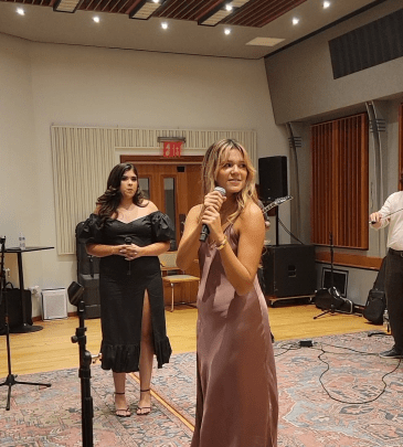 Bella Stine signs into a microphone at Fount Studios