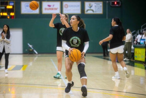 Female PLNU basketball student practices for game in warm-ups.